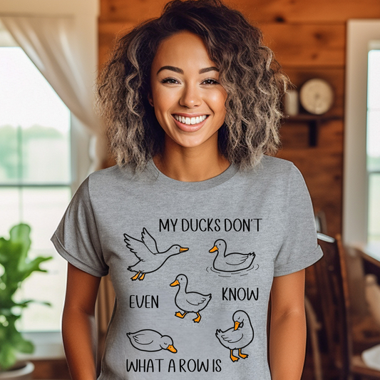 Woman wearing a gray t-shirt with duck graphics and text in a home setting