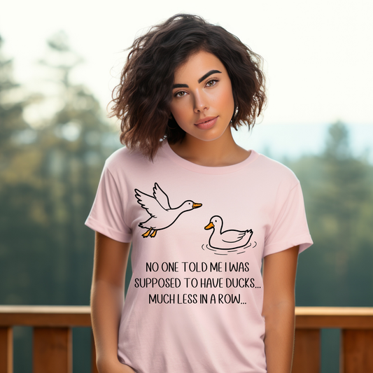 Woman wearing a pink t-shirt with duck graphics and text outdoors